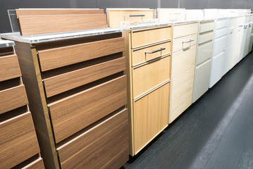 Samples of furniture cabinets with drawers of different colors at an exhibition in the store