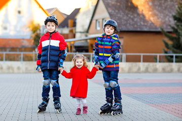 Two kids boys and little toddler girl playing together outdoors on sunny day. Brothers in...