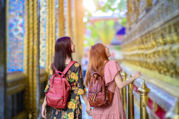 young tourist women walking in walk pathway of the palace temple in Bangkok of Thailand, Emerald...