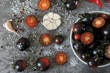 Black tomatoes. Cherry tomatoes with spices. Top view.