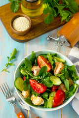 Concept for a tasty and healthy meal. Salmon Grilled Salad with cucumber, tomatoes, fresh arugula and sesame seeds. Home made food.