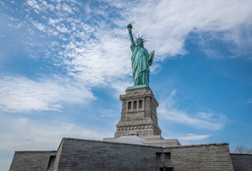 Obraz premium Shot of the Statue of Liberty in New York City, Usa. The shot is taken during a beautiful sunny day with a blue sky and white clouds in the background 