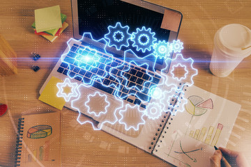 Double exposure of hands and notepad with business icons.