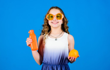 happy girl drink fresh orange juice. summer vacation. little girl in fashion glasses. Vitamin nutrition. vitamin juice. Health. Summer vitamin diet. Natural vitamin source. Making nutritional choice