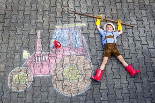 little kid boy having fun with tractor chalks picture