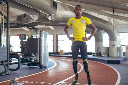 Disabled African American male athletic standing on running track in fitness center