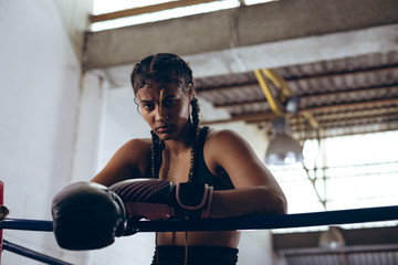 Portrait of boxer leaning on rope in boxing ring