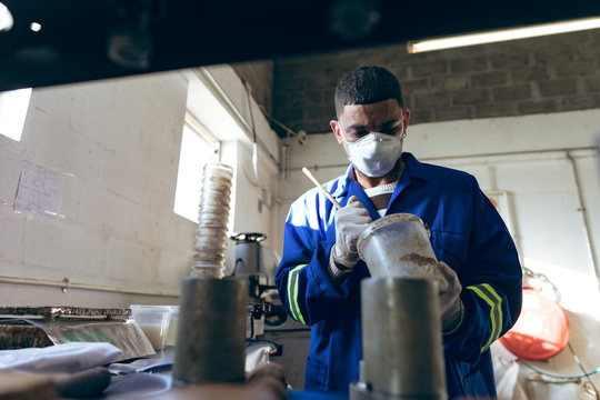 Young man working in a sports equipment factory