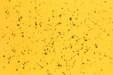 Golden sparkles on bright yellow trendy background.