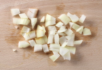 Fresh cut onion slices on wooden chopping board isolated on white background