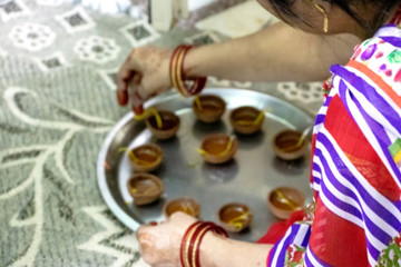 Happy diwali - A woman hand holding or arranging diwali diya or clay lamp