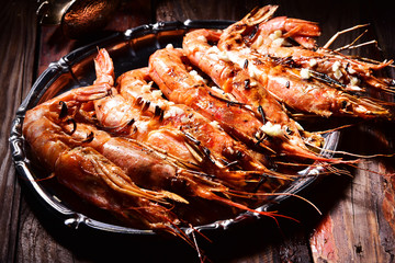 Beer and langoustines on a dark background.