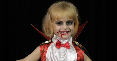 Dracula child. Girl with halloween make-up. Vampire kid with blood on her face