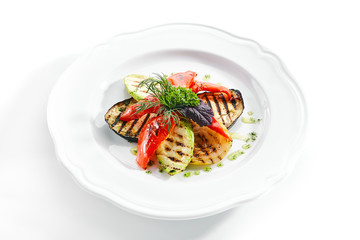 White Restaurant Plate of Grilled Vegetables and Fresh Greens Isolated