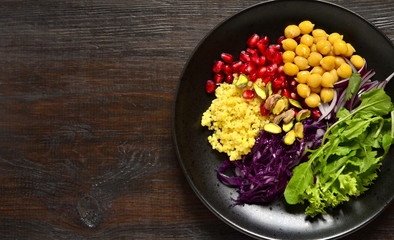 Healthy vegetarian salad. Millet, chickpea, pomegranate seeds, red cabbage, onions, arugula. Buddha bowl, top view, copy space