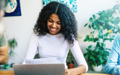 Beautiful young african woman in office. Modern happy start up team in casual clothes in office or co-working space are working and discussion them plans and ideas.