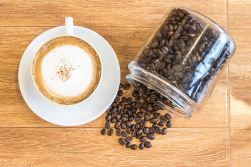 A cup of cappuccino with coffee bean as background..