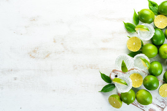 Tequila with salt and lime on a white wooden background. Fruits. Top view. Free space for your text.