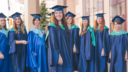 A group of young female graduates. Female graduate is smiling against the background of university graduates.