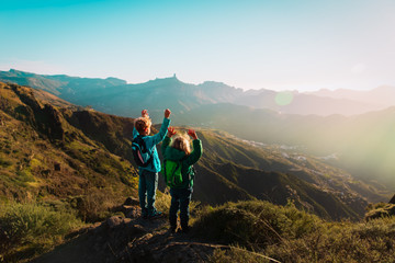 Fototapeta premium happy boy and girl travel in mountains at sunset, kids enjoy hiking