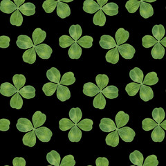 Watercolor hand drawn seamless pattern with lucky clover four leaf isolated on black background.