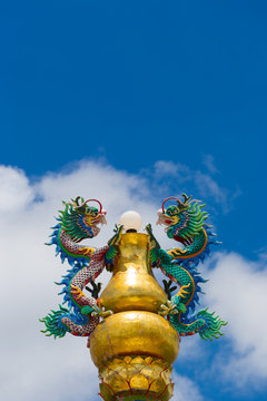 Dragons sculpture on a pillar with blue sky background. Photo is taken from public place Chao Pu-Ya Shrine, Udon Thani Thailand.