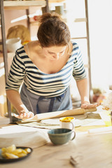 Beautiful woman making ceramic ware in workplace in sun light. Concept for woman in freelance, business, hobby