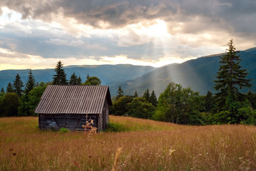 An old house built of wood on meadow in mountain