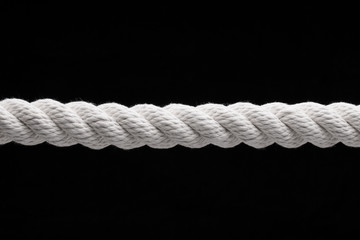 Stretched rope. White thick rope on a black background.