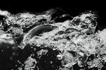 Bursts of bubbling water close-up. Water boiling over black background.