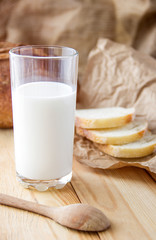 Glass of milk with slices of bread on a wooden table.Brown bread on the table