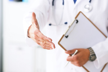 Male medicine doctor hold pad and give arm to shake in office closeup. Friend welcome introduction...
