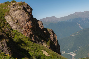 on alpine meadows of a mountain range at an altitude of more than 2 thousand meters - a view of the mountain peaks, sky and clouds of the ski resort on a sunny summer day in the Caucasus mountains