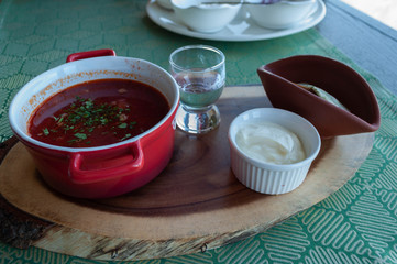 traditional food in the Kuban (southern Russia) in the alpine restaurant of the ski resort - borsch, smatana, a glass of moonshine and bread