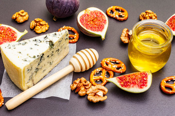 Cheese appetizer selection or wine snack set. Blue cheese, figs, honey, walnuts, pretzels