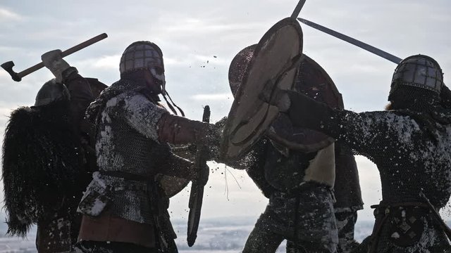Warriors of vikings are fighting during attack at winter time.