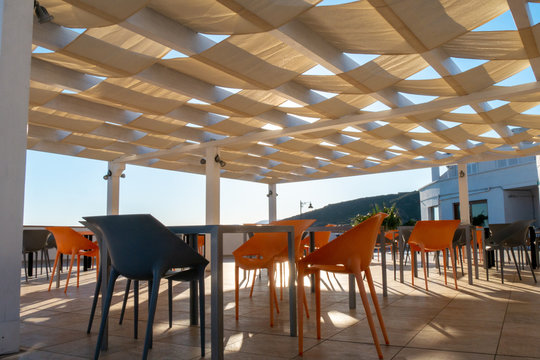 woven sheeds. sunshade. orange and black chairs