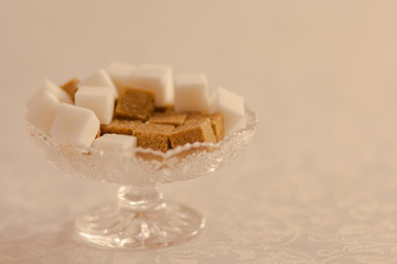 Refined white and brown sugar in a glass vase on table