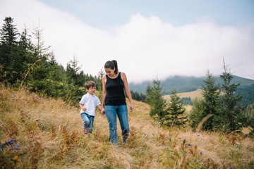 Obraz premium Young mom with baby boy travelling. Mother on hiking adventure with child, family trip in mountains. National Park. Hike with children. Active summer holidays. Fisheye lens