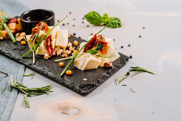 A dish with different cheese, honey and spices on the wooden background