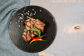 Tasty roasted steak with spices on the wooden background