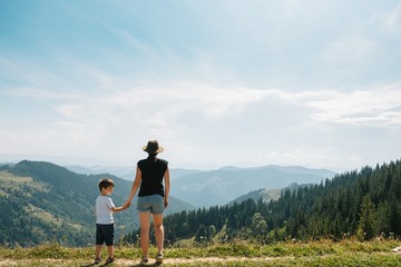 Young mom with baby boy travelling. Mother on hiking adventure with child, family trip in mountains. National Park. Hike with children. Active summer holidays. Fisheye lens