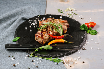 Tasty roasted steak with spices on the wooden background
