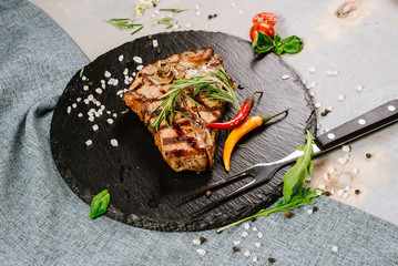 Tasty roasted steak with spices on the wooden background