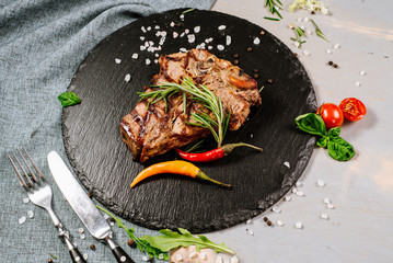 Tasty roasted steak with spices on the wooden background