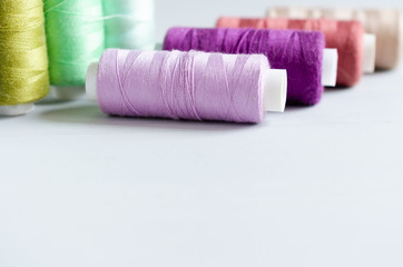 Multi-colored spools of sewing threads close-up. Craft and hobby concept.
