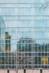 Obraz premium New York City, NY, USA - December, 2018 - Streets of Manhattan, Skyline view reflected like a mirror in a building in front of Bryant Park.