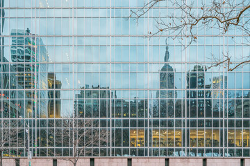 New York City, NY, USA - December, 2018 - Streets of Manhattan, Skyline view reflected like a mirror in a building in front of Bryant Park.