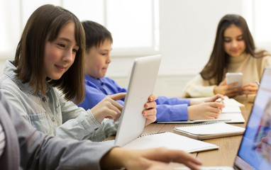 E-learning in school. Girl doing homework, using digital tablet
