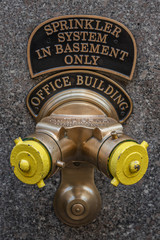 New York, NY, USA - December, 2018 - Golden and yellow ancient Fire hydrant standpipe and sprinkler connection.